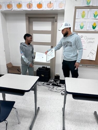 Kaypree Taylor, a R.I.S.E. staff member, works with a youth on their reading skills and assists other youth participants during classroom time.