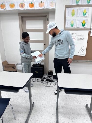 Kaypree Taylor, a R.I.S.E. staff member, works with a youth on their reading skills and assists other youth participants during classroom time.