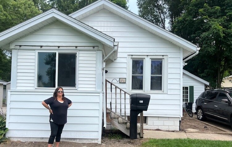 Loni White, an Early Childhood Educator, stands in front of her home in Battle Creek.