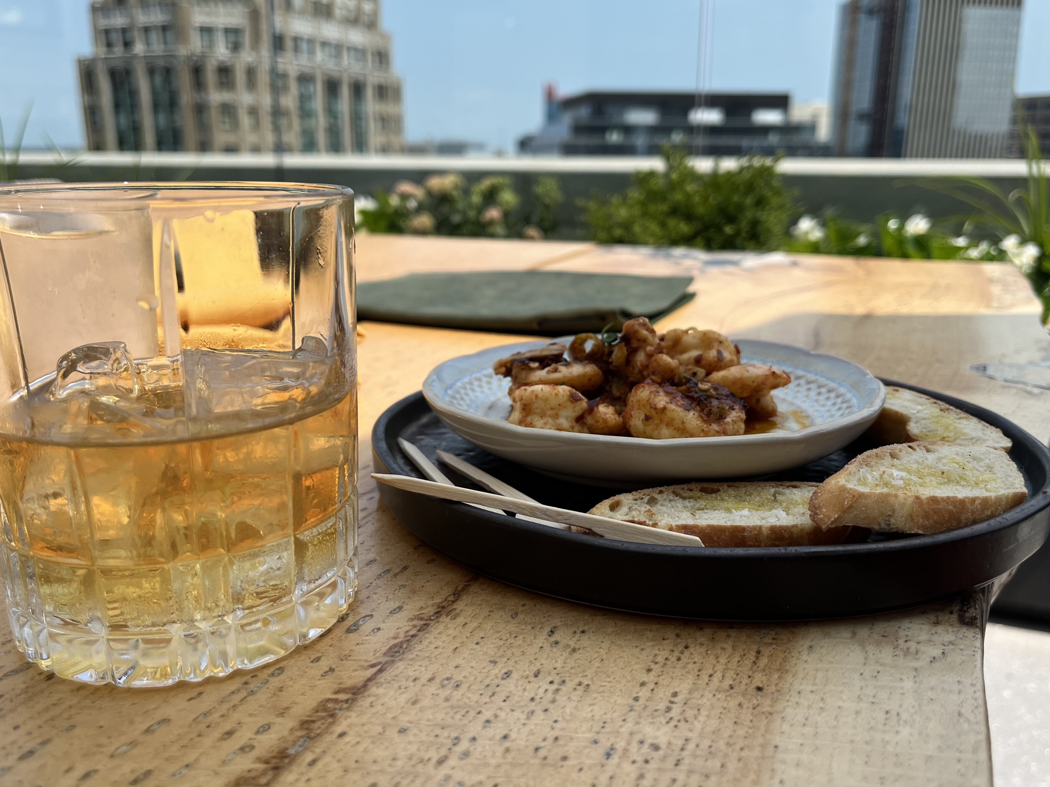 Rye and a tapas plate of shrimp for a "bougie" lunch at Kamper's Rooftop Bar in the Book Tower.