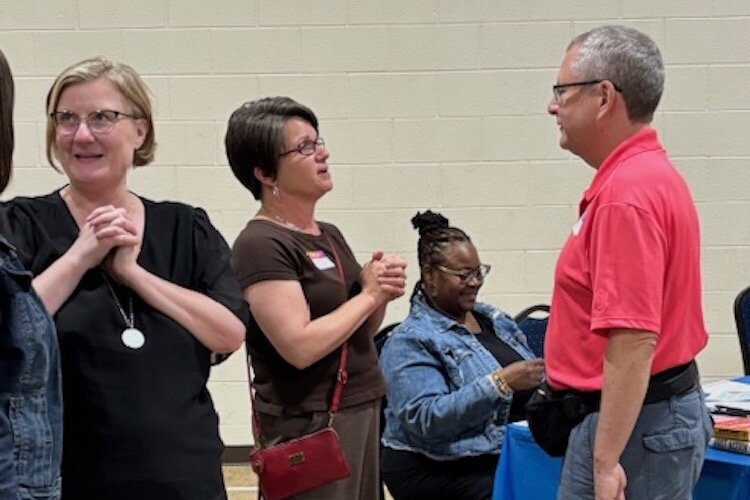 Mary Muliett, President and CEO of the Battle Creek Community Foundation, center, talks with a community resident at the Building Equity event.