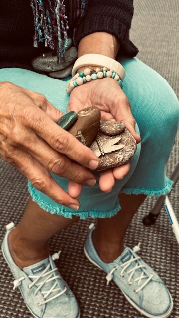 Linda Tafolla carefully holds the "Rock Dancers" (rock collages) that began making during COVID-19 as a way to get through the Pandemic.