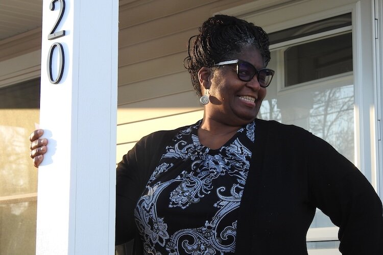 Kalamazoo resident Kimberly Whittaker poses outside the home she moved into in July. The home was one of 48 built via the city’s collaboration with Kalamazoo Neighborhood Housing Services, the Home Builders Association of Western Michigan, and LISC.