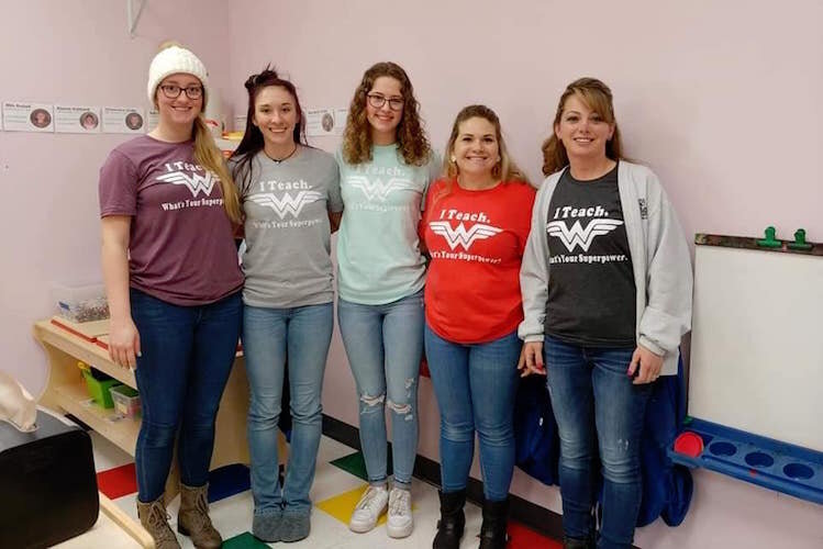 Learning Zone staff members wear matching shirts saying "I teach, whats your super power?" and a Wonder Woman symbol. 