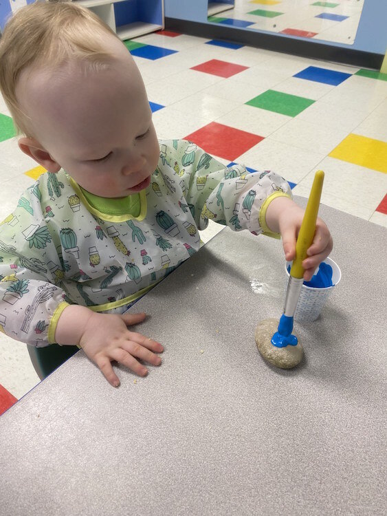 Infants practice rock painting at Learning Zone. 