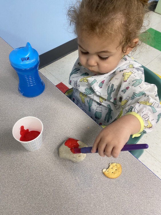 Infants practice rock painting at Learning Zone. 