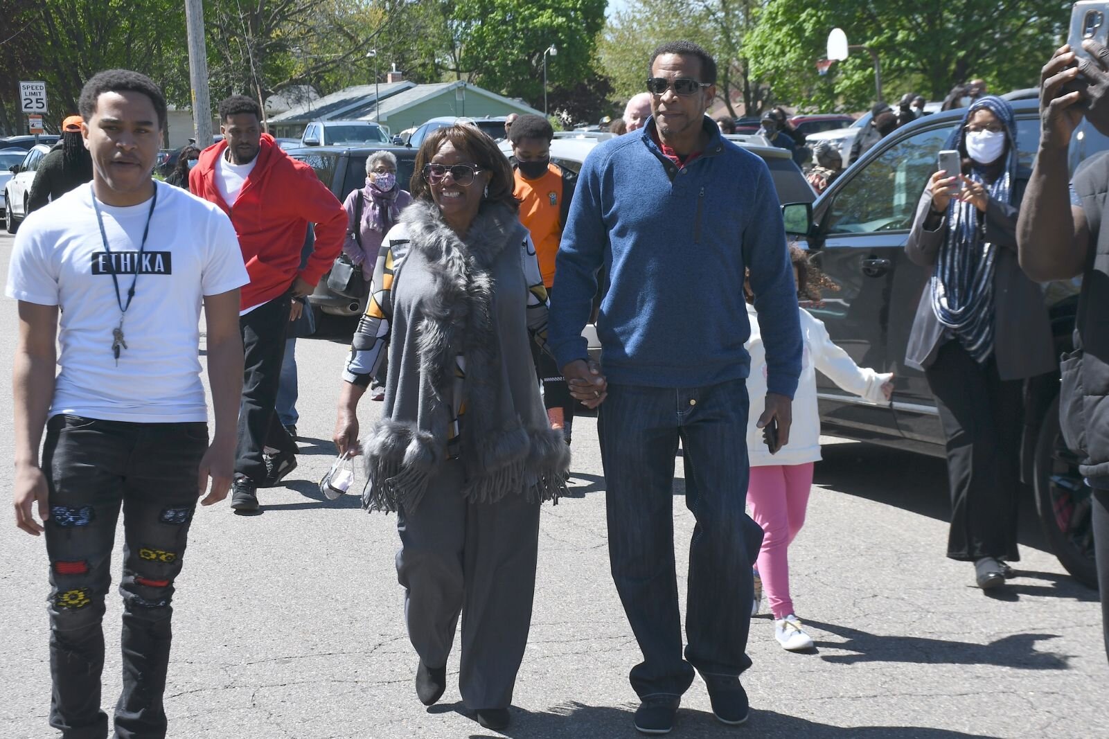 Johnny Bristol, Jr., holds hands with his mom Maude Bristol- Perry as they walk toward the street sign of Honorary Mayor Maude Bristol-Perry Avenue.