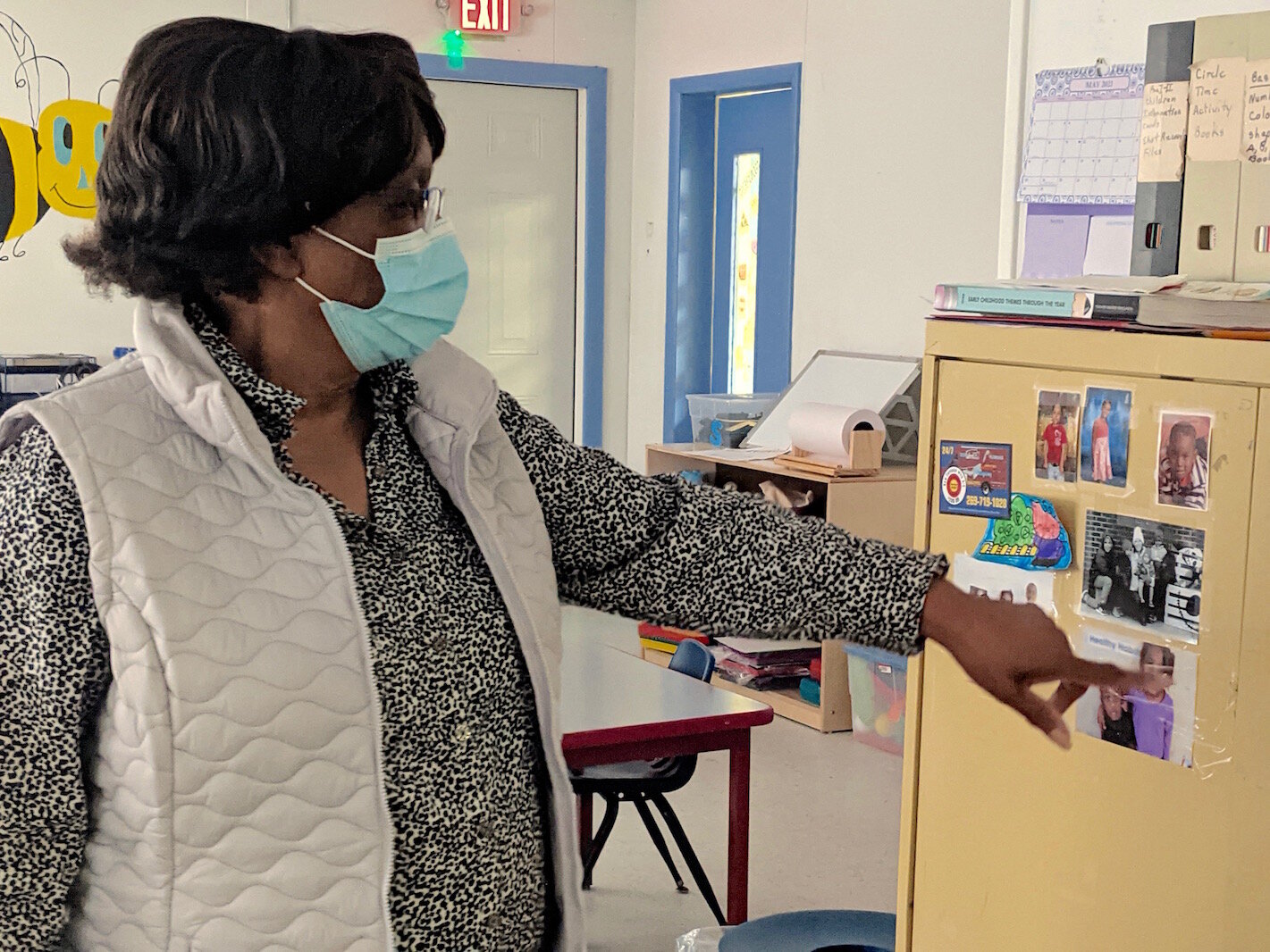 Maude Bristol-Perry, owner of Sugar and Spice Childcare Center, points to a photo of children who were cared for at Sugar and Spice. She has an area where she displays the photos.