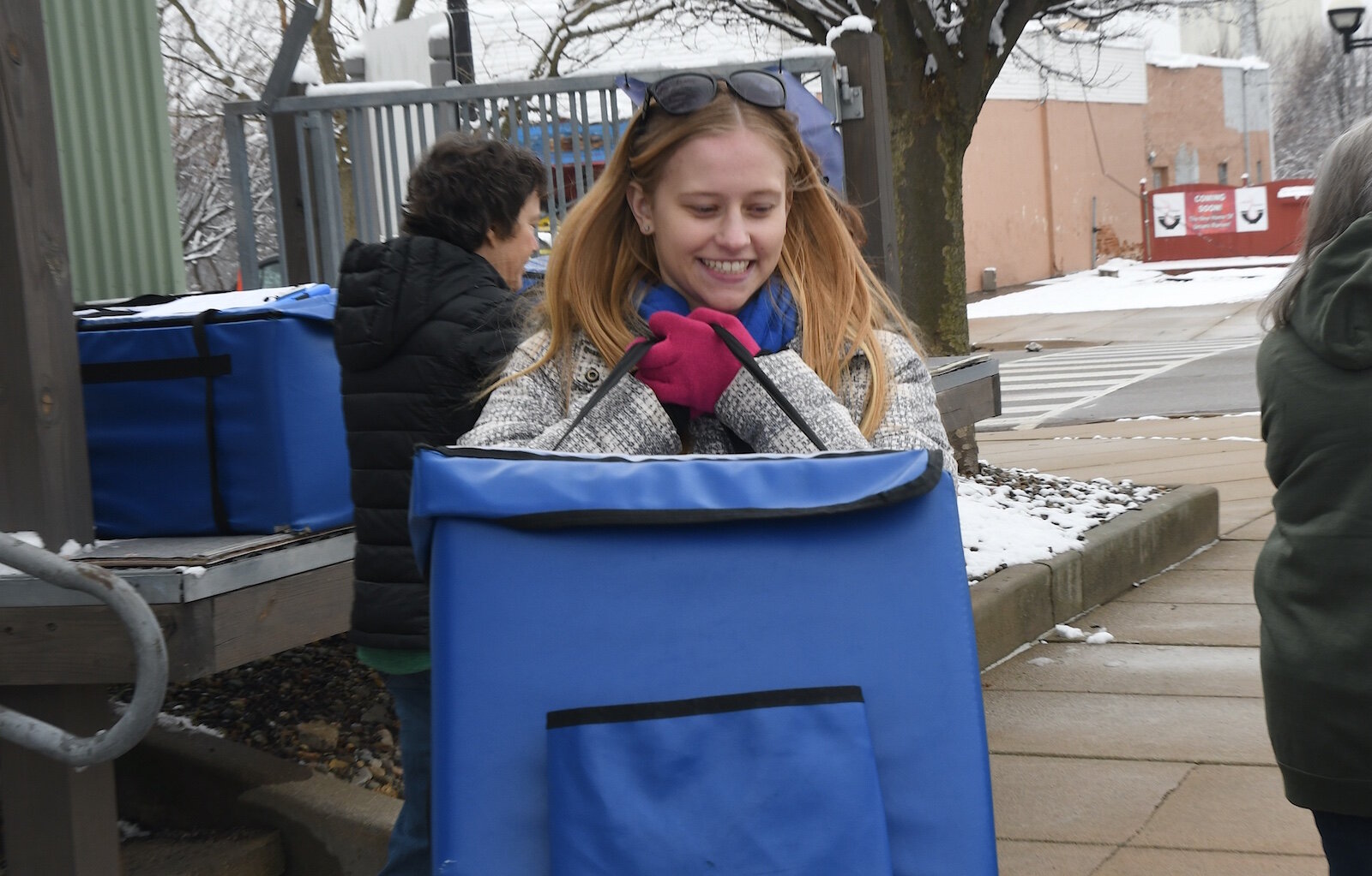 Kate Turner a volunteer meal deliverer carries meals to her vehicle.