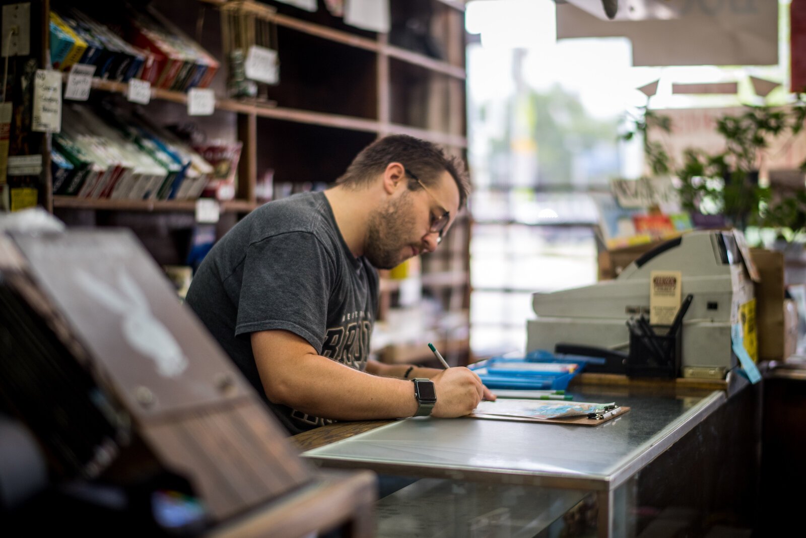 Alex George behind the counter working at Michigan News.