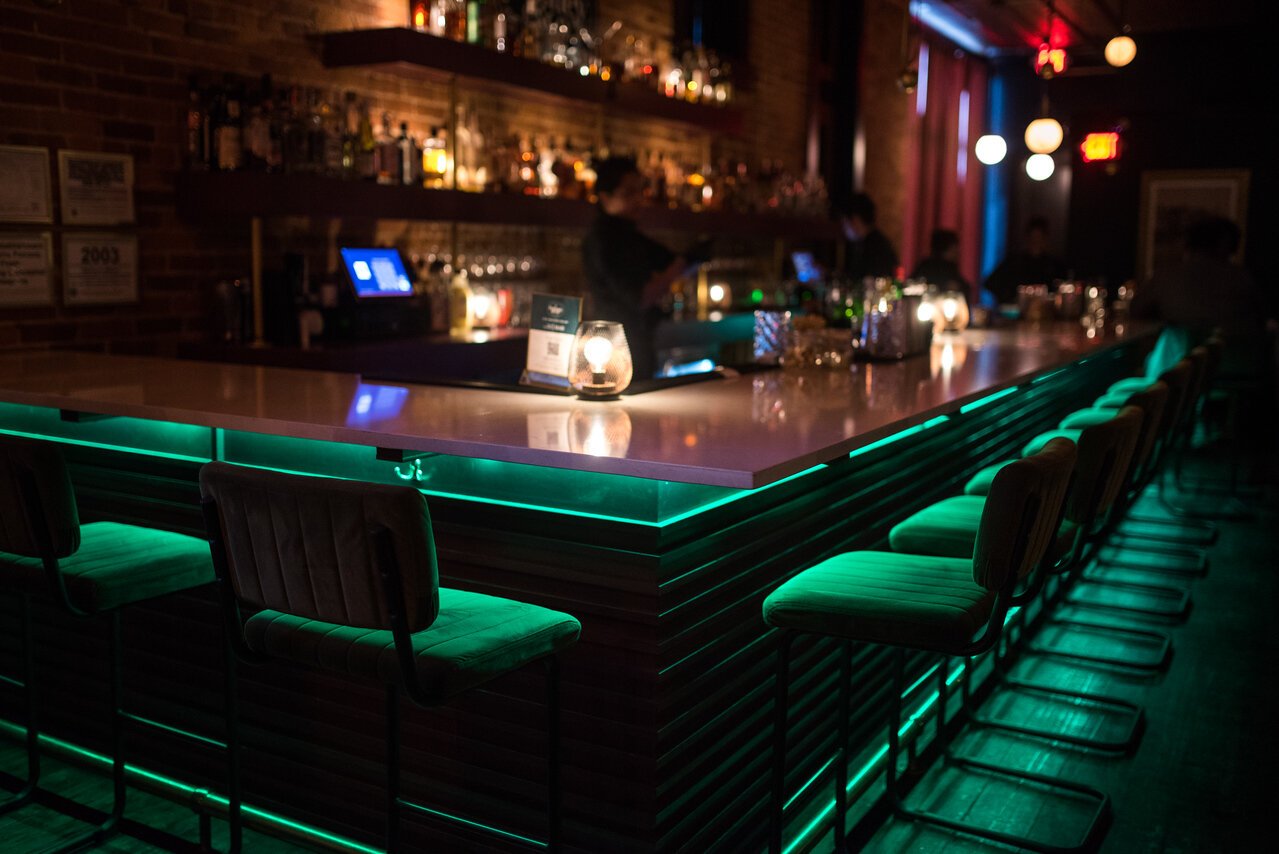 The green glow of the bar creates a congenial vibe at Dabney & Co.