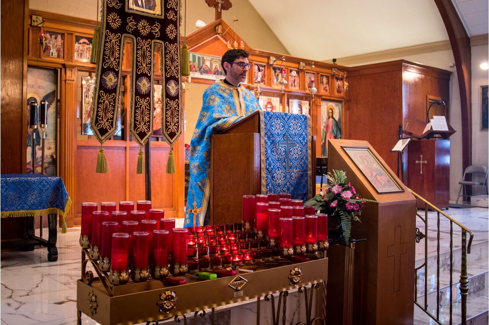 Father Bryce standing in front of the church delivering a sermon.