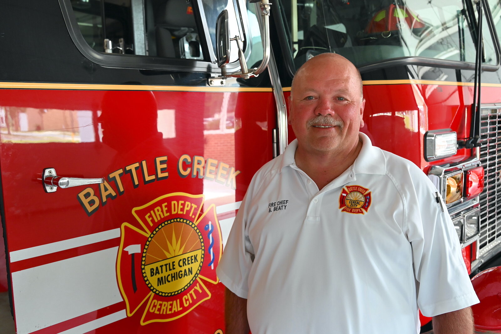 Battle Creek Fire Department Chief Bill Beaty stands by a couple of fire trucks inside Central Fire Station.