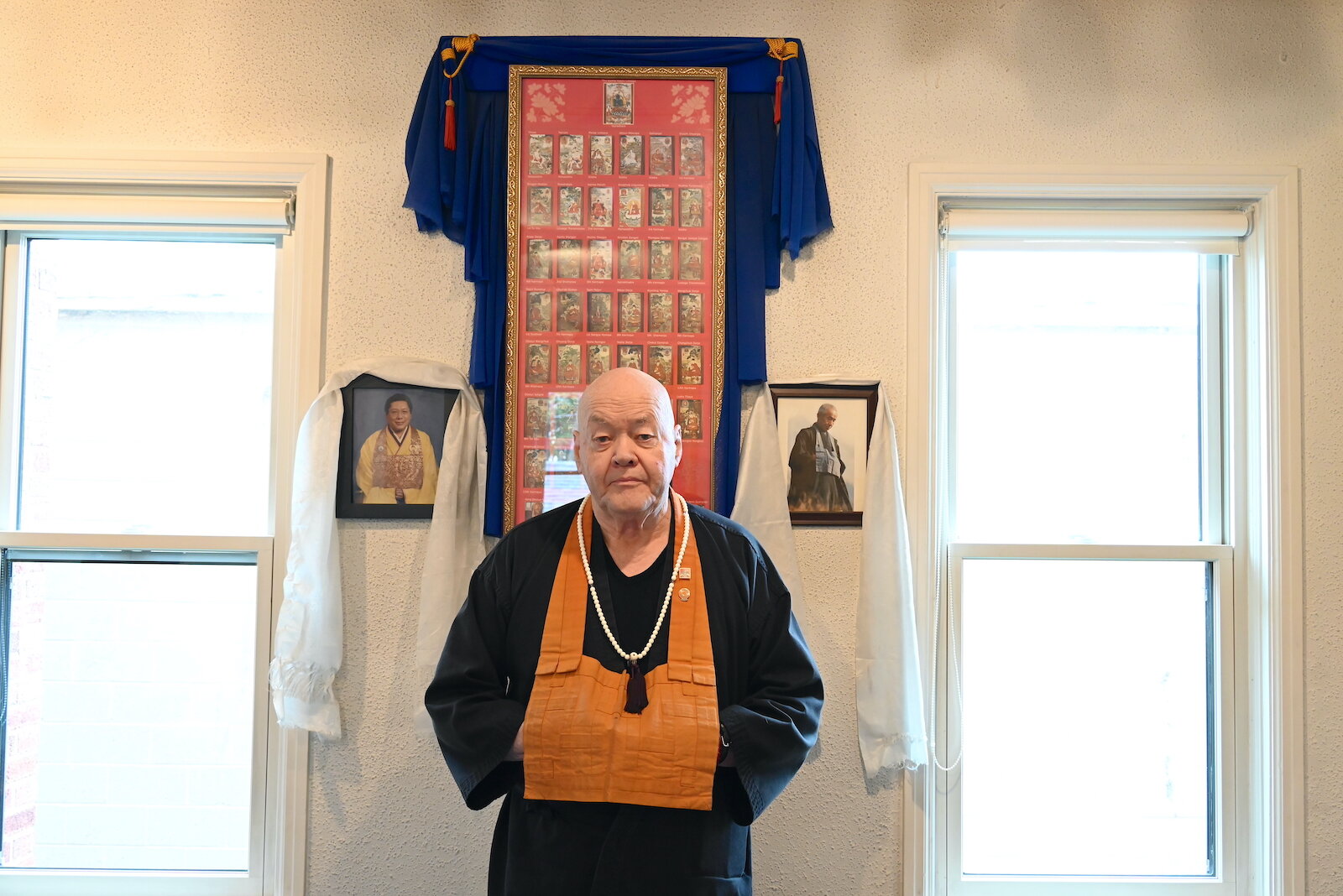 Sokuzan, founding abbot of SokukoJi Buddhist Temple Monastery, stands in front of photos of his teachers, Chögyam Trungpa Rinpoche, left, and Kōbun Chino Otogawa Roshi.