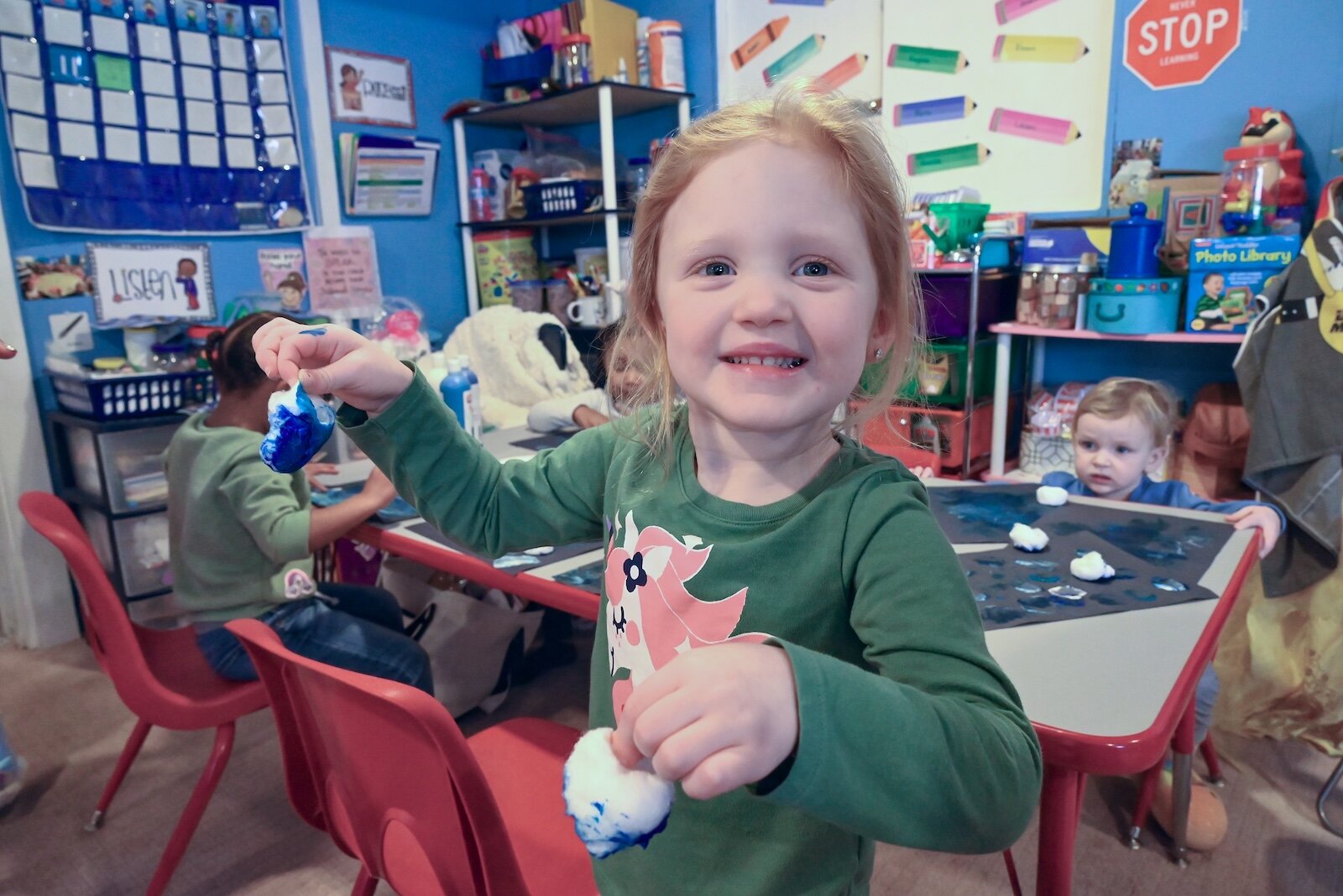 Lakelyn Webb shows off cotton balls she used for painting a winter picture.