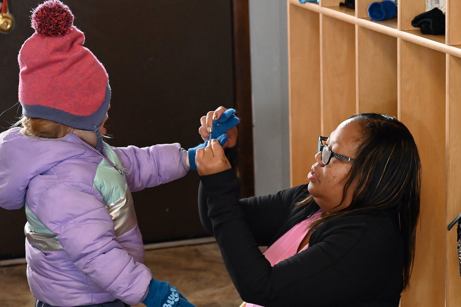 Kim Spivey helps one of her children put on gloves before an outdoor activity.