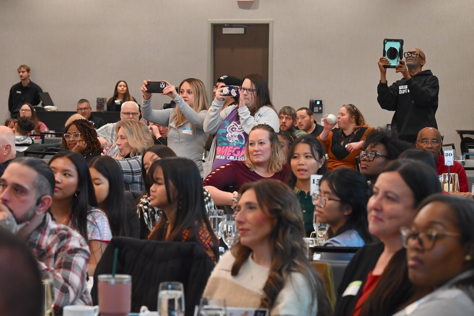 Members of the audience listen and some take photos while members of the Sojourner Truth Choir sing during the National Day of Racial Healing event.