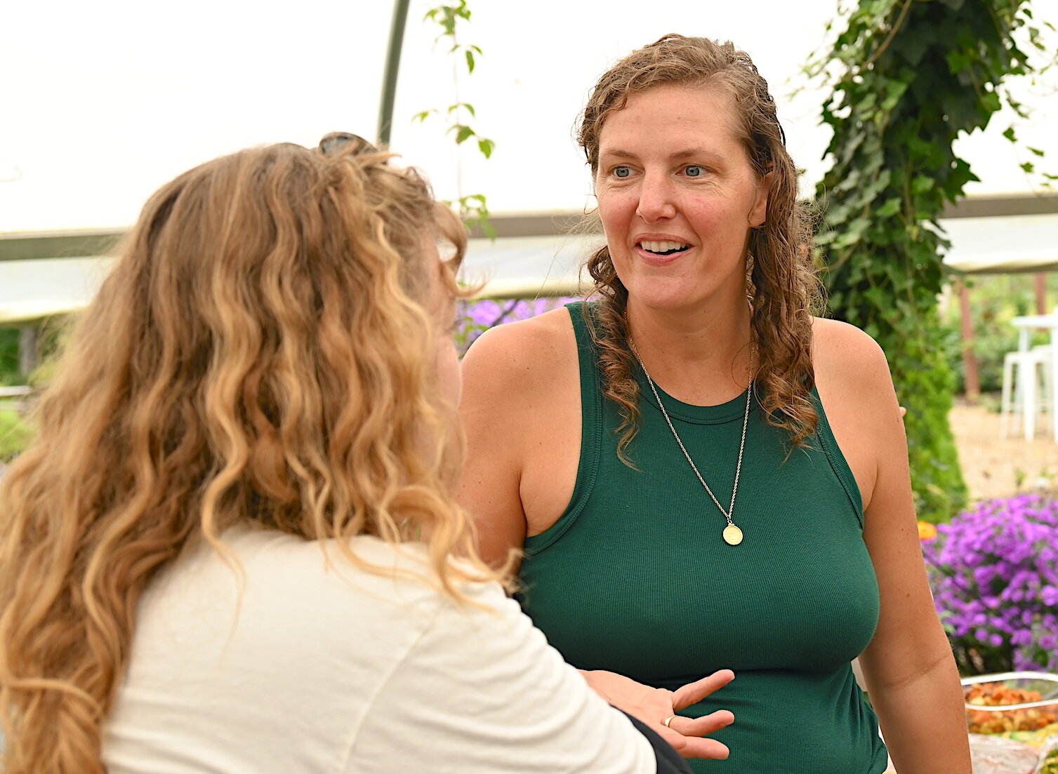 Bridget Blough, a co-owner of Of The Land, talks with friends during the harvest festival.