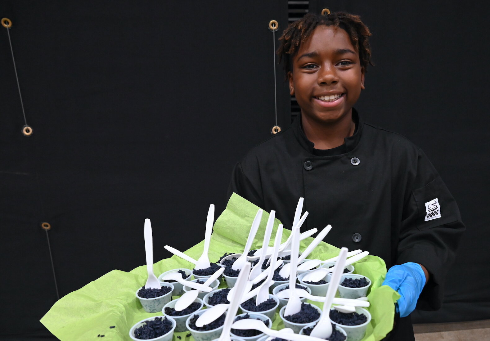 Emmanuel Boyd serves up black rice during the Village Network’s Rice and Flavor event at Kellogg Arena.