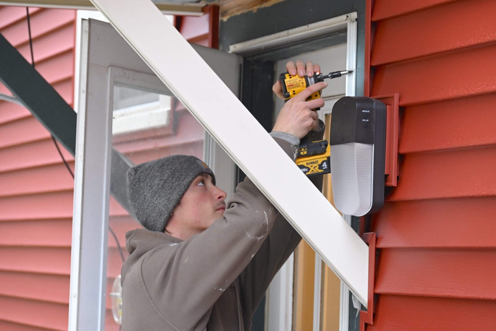 Ryan Georgopoulis works on a door at a house in Albion being renovated to remove lead.