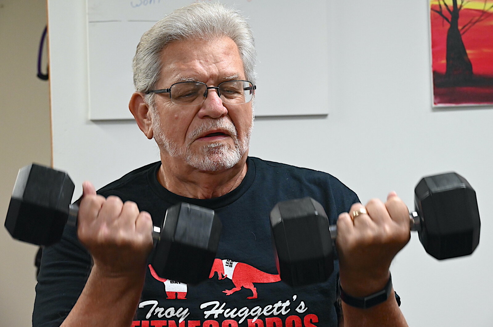 Chuck Crider works on arm strengthening exercises at Troy Huggett’s Fitness