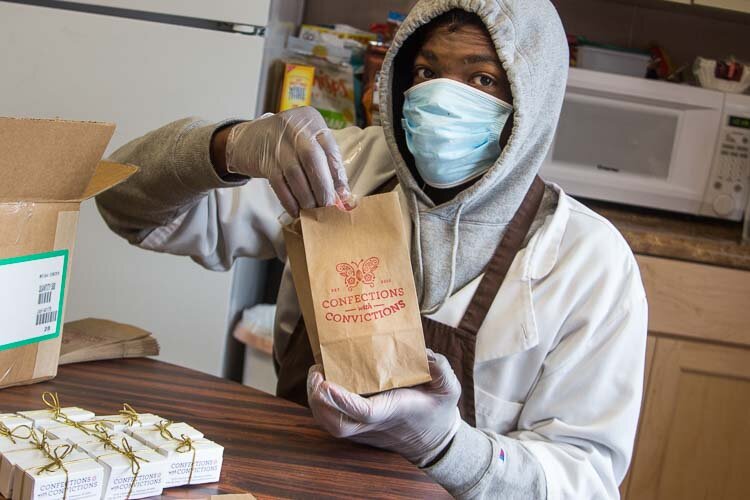  Employee Sincere Rostick packing up treats from Confections with Convictions 