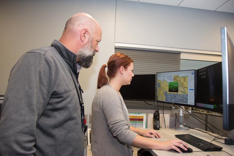 Kevin Kellums and Whitney Perigo, crime analyst, at work at the Fusion Center.