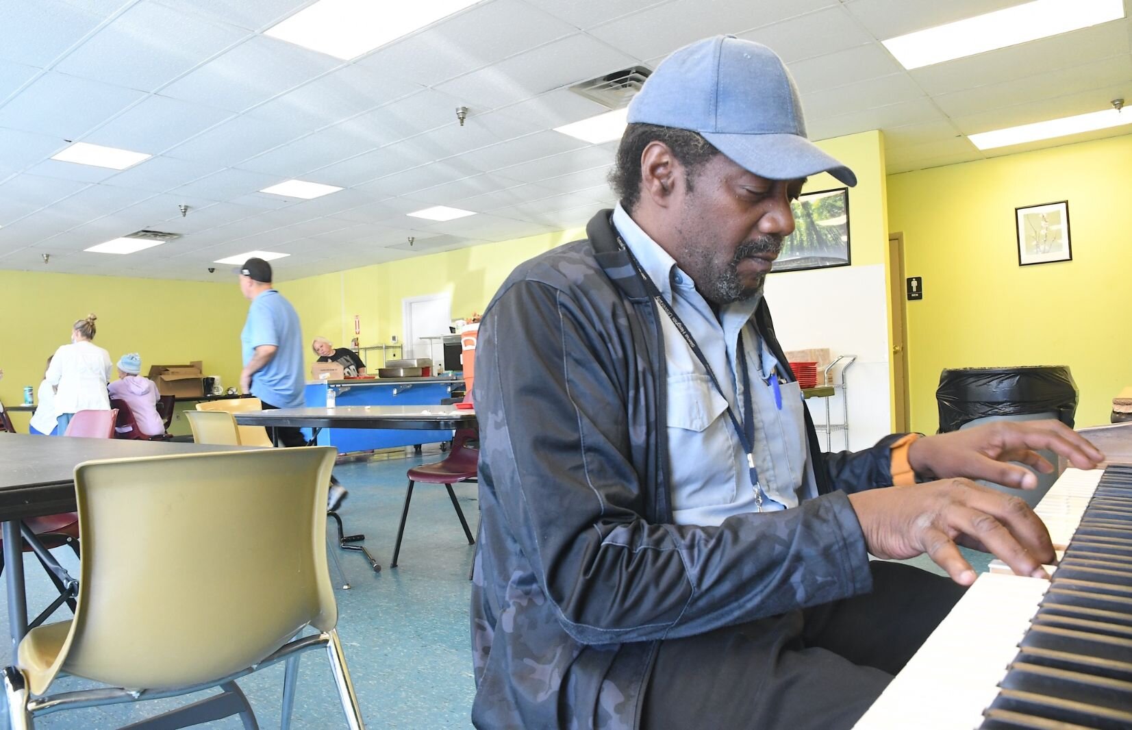 Ronald Leigh, staffer at The Haven of Rest, plays piano during lunch time at the SHARE Center.