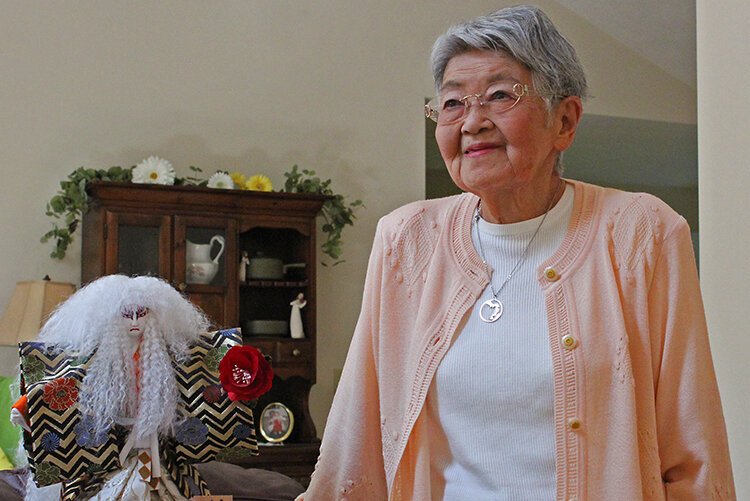 Tsugi Ogane poses with a doll she gave to her hosts, Tom and lois Hoekstra.