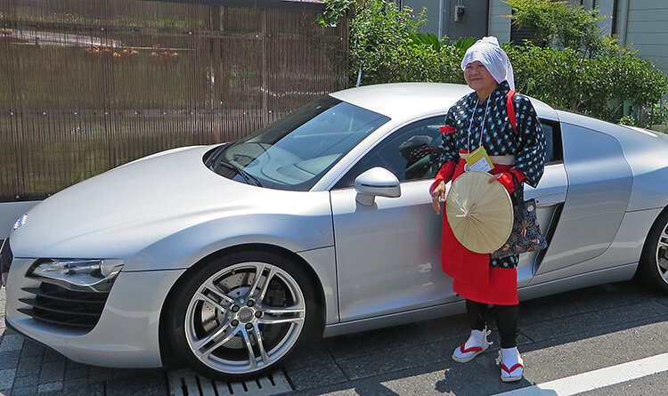 Tsugi Ogane displays traditional attire for picking tea leaves.