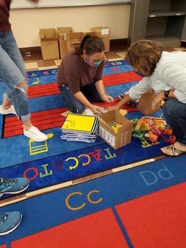 Volunteer prepare donations to go to families in the school district.