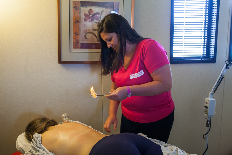 Katie Kuhn performs a cupping treatment for Erica Brooks.