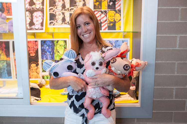 Joanie Roehl shows off the creepy dolls her art students created.