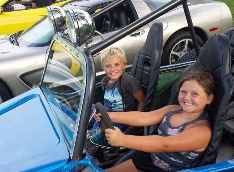 Children enjoy exploring cars during the Tires & Treads supply delivery event.