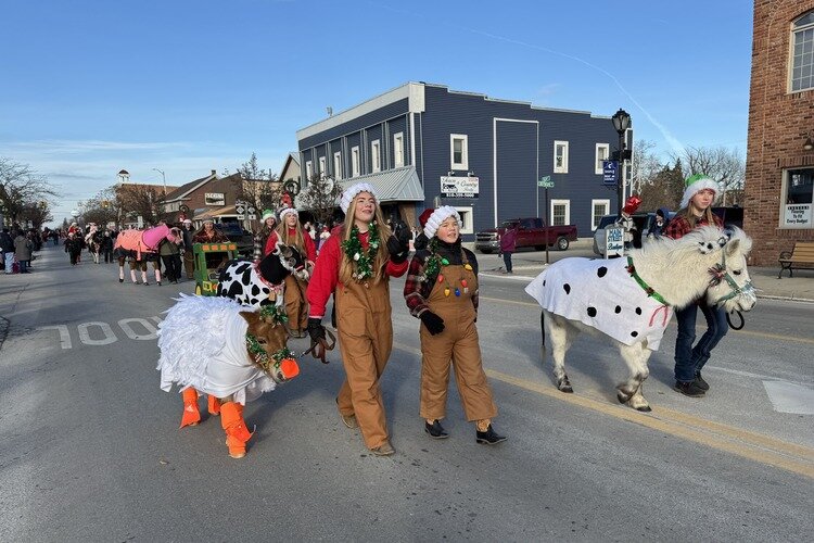 Kids sporting Santa hats march with their gaily decorated ponies down Main Street in Lexington.