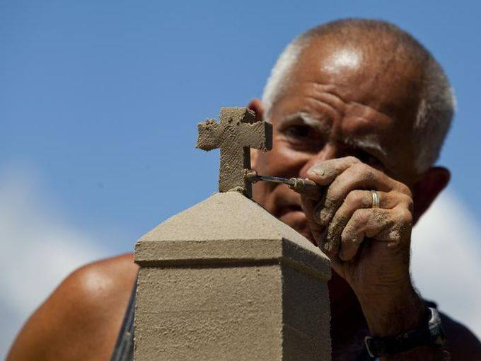 A sculptor works on his piece in a previous contest.