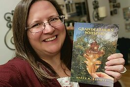 Stacy Elliott holding her book Grandfather's Whispers.