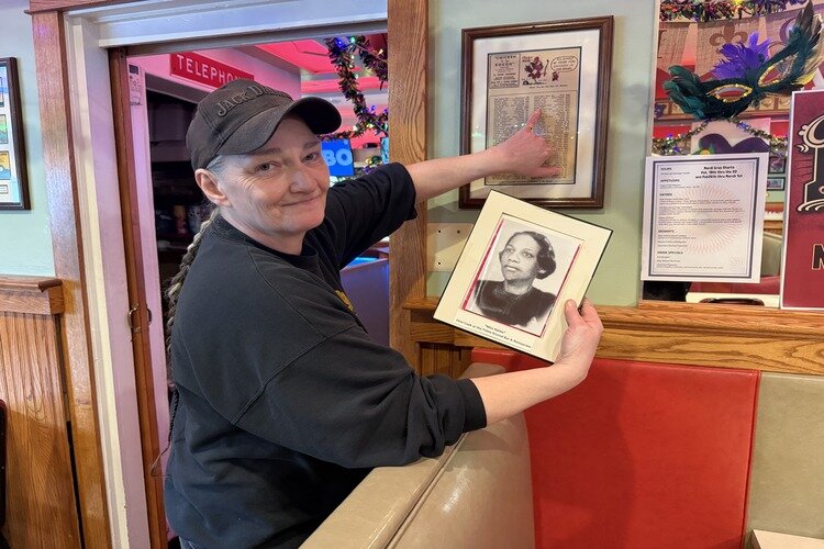 Sandy Karbowski holding a photo of Hattie Dunlap, the restaurant’s first cook.