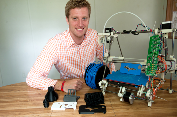 Ben Wittbrodt poses with the 3D printer that helped launch his business. 