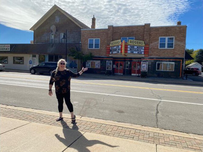 Amber Alexander, director of the Presque Isle District Library, stands in front of the historic Rogers Theater.