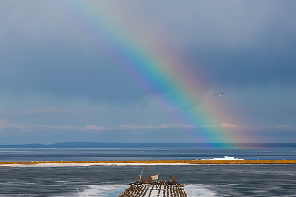 the first rainbow of Spring appears over a thawing Marquette Lower Harbor 