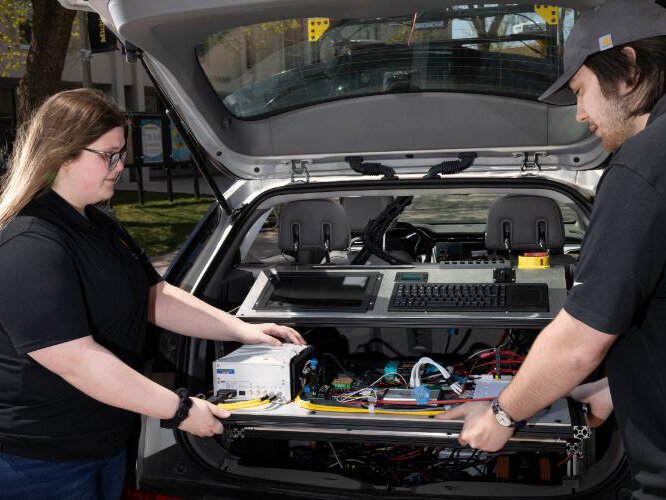 Members of the Supermileage Systems Enterprise install an engine in their ultra-high mileage competition vehicle.