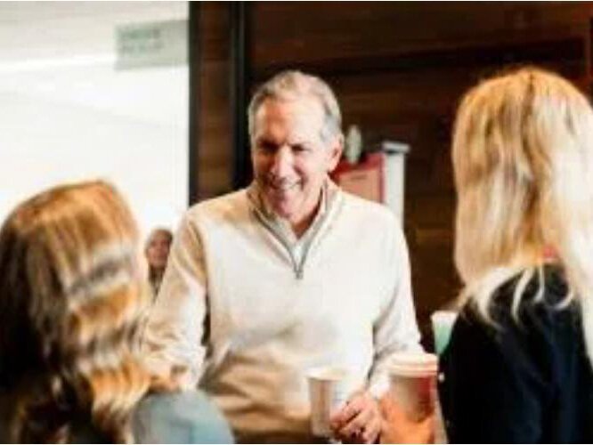 Howard Schultz (middle) speaks with students at a fireside chat in the Jamrich Hall Starbucks location after gifting $1 million to Northern Michigan University.