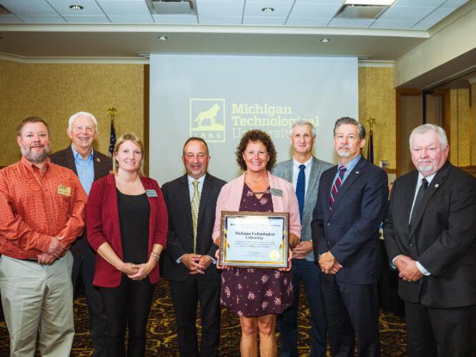  Local elected officials and Michigan Tech staff pose with the Donnelly Award after it was presented to the university on Oct. 11.