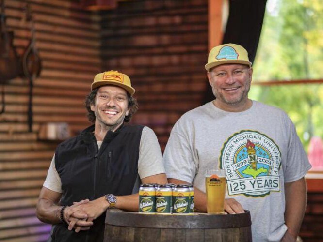 NMU alumni Steve Farr (left) and Blackrocks co-owner Andy Langlois with the branded Wildcat Gold Lager cans.